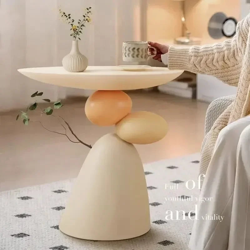 Minimalist cream-coloured side table with a unique stacked, sculptural base, perfect for modern living spaces.
