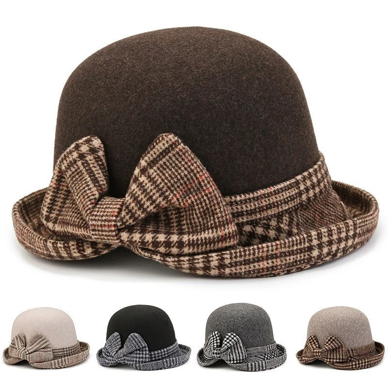 A dark brown felt bucket hat with a stylish plaid brim and matching decorative bow. Available in four colourways.