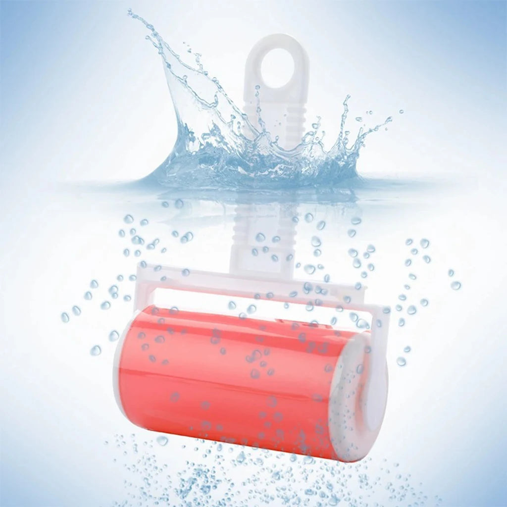 A reusable pink sticky lint roller with a white handle, shown submerged in water with a splash.