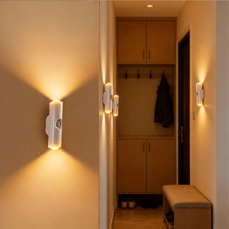 Minimalist white rechargeable LED wall lights with motion sensors emitting a warm, dual-directional glow in a hallway.