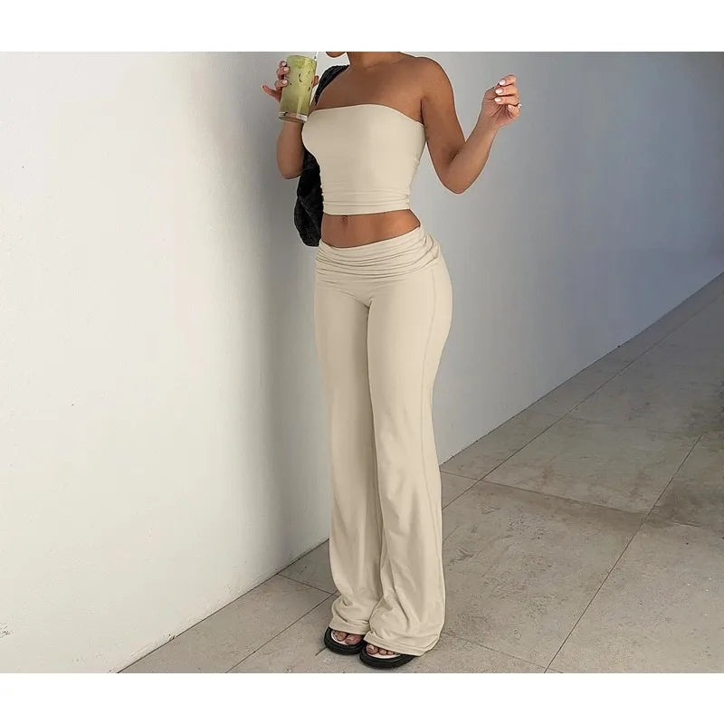 Beige co-ord set featuring a strapless crop top and high-waisted, flared trousers with a gathered waistband.