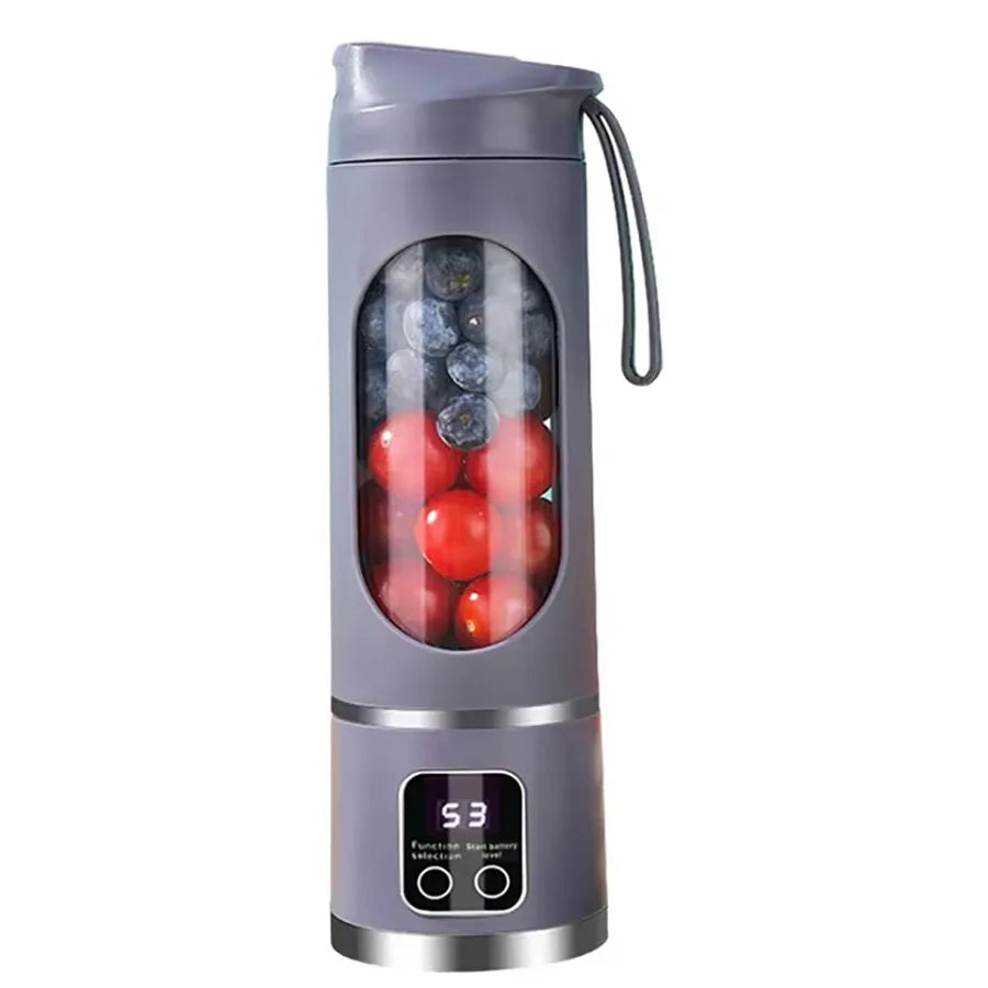 Grey portable blender with a clear window showing blueberries and tomatoes, digital display, and a carrying strap.