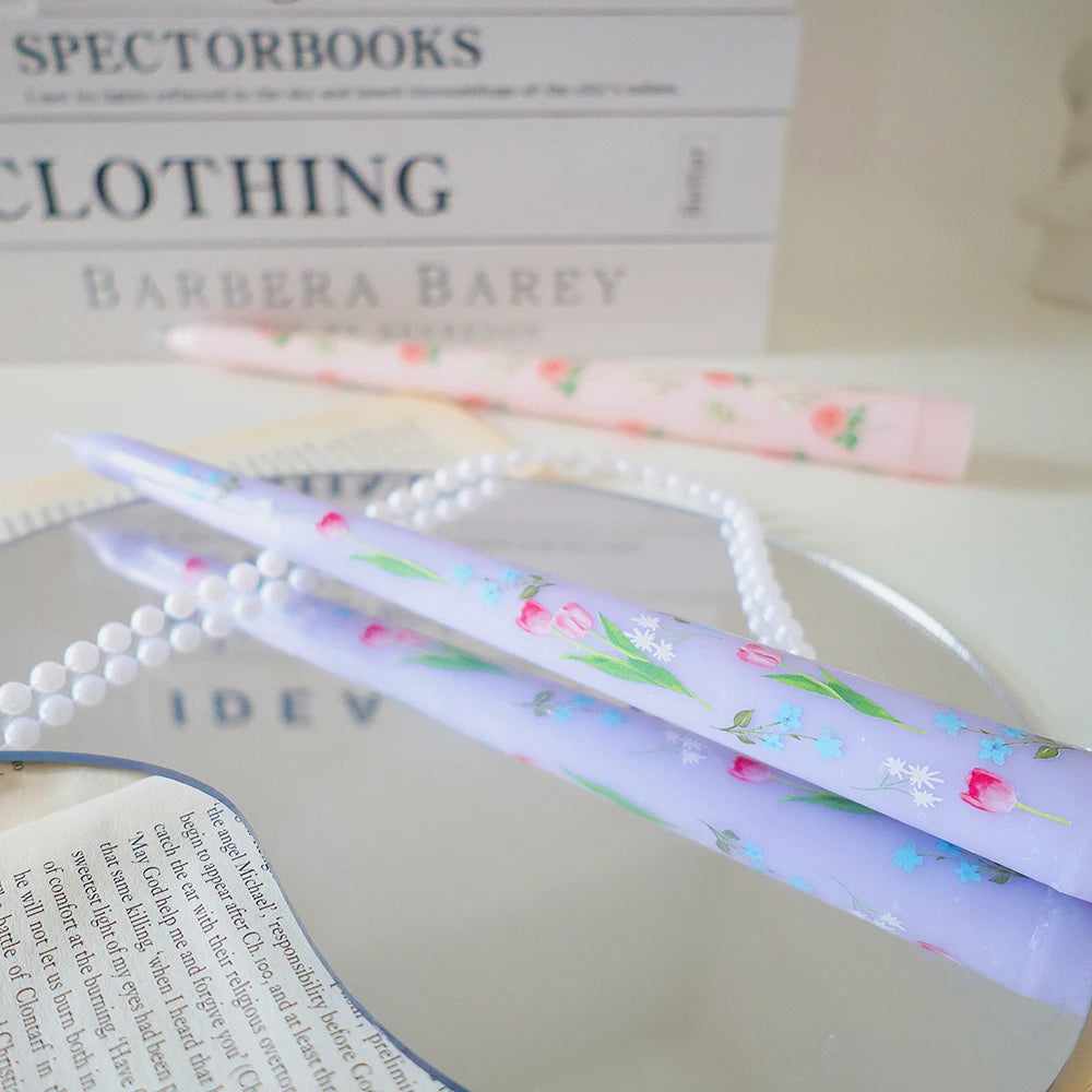 Pair of tapered dinner candles in soft lilac with delicate pink tulip and blue floral print.