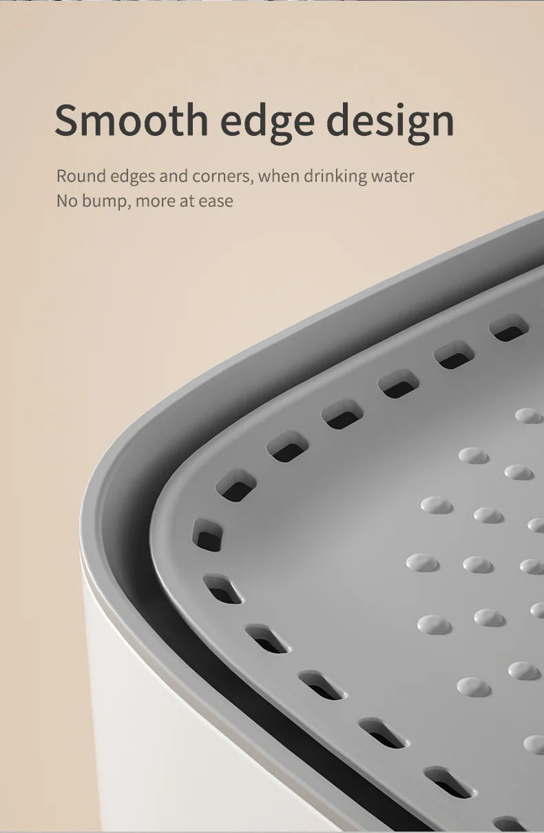 Close-up of a grey, rounded water fountain tray with a perforated drainage design and smooth, safe edges.