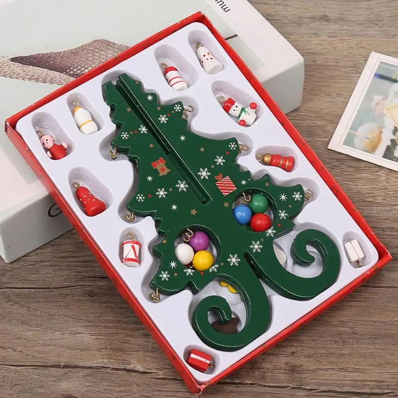 A green, wooden Christmas tree ornament in a box, featuring decorative snowflake patterns and small hanging baubles.