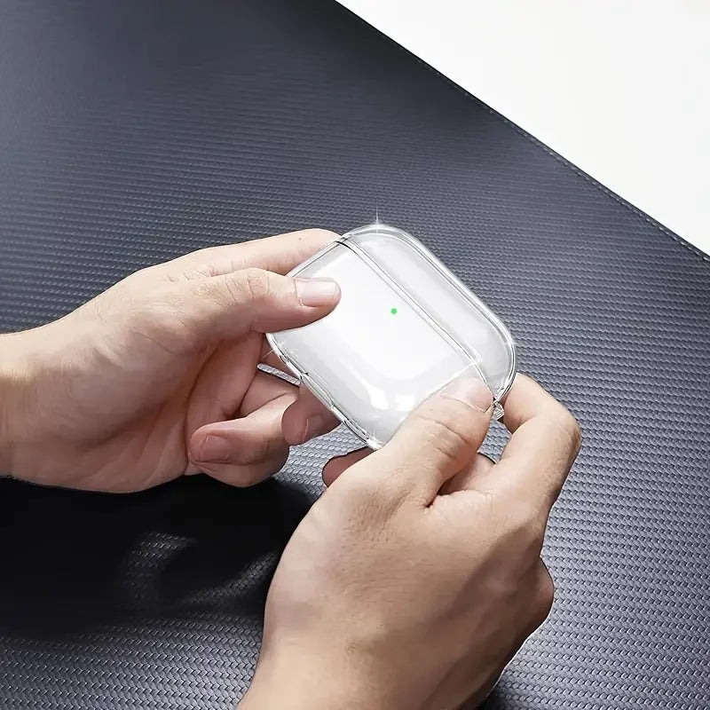 Clear, protective silicone case for AirPods Pro held in hands on a black textured surface.