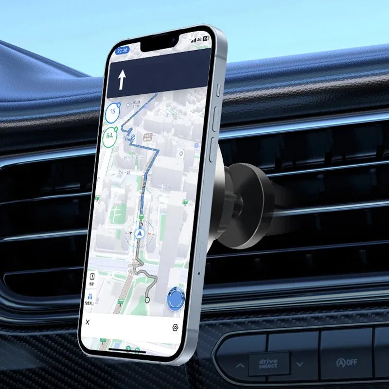 Smartphone mounted on a minimalist silver circular magnetic car air vent holder displaying a navigation map.