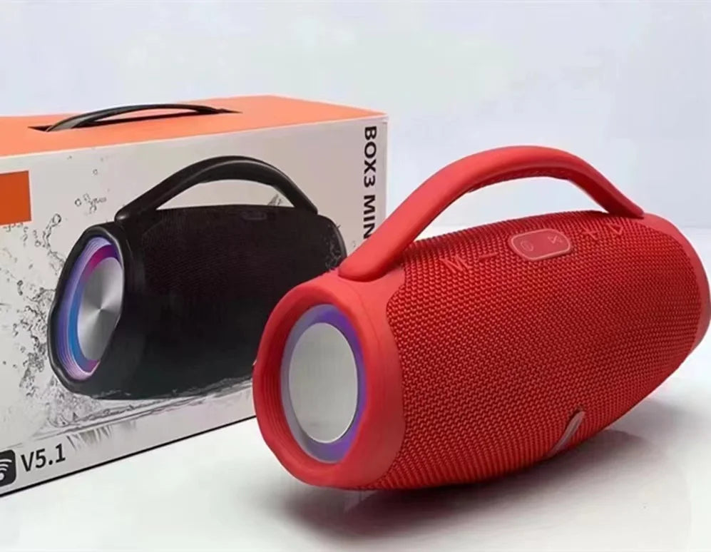 Red 100W portable Bluetooth speaker with built-in handle and RGB light ring, shown with its product packaging.