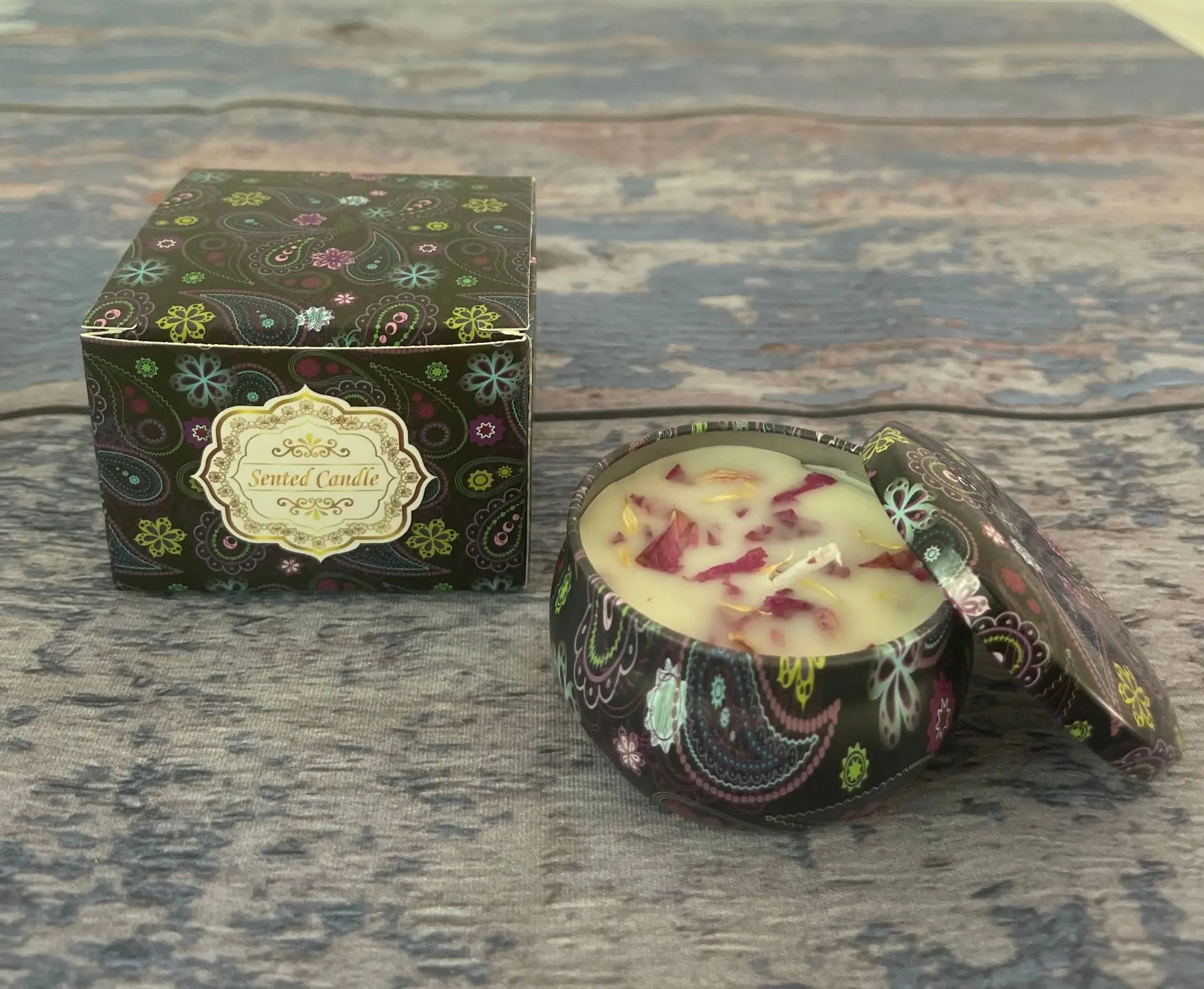 Scented candle in a decorative paisley tin with matching gift box and dried flower petal topping.
