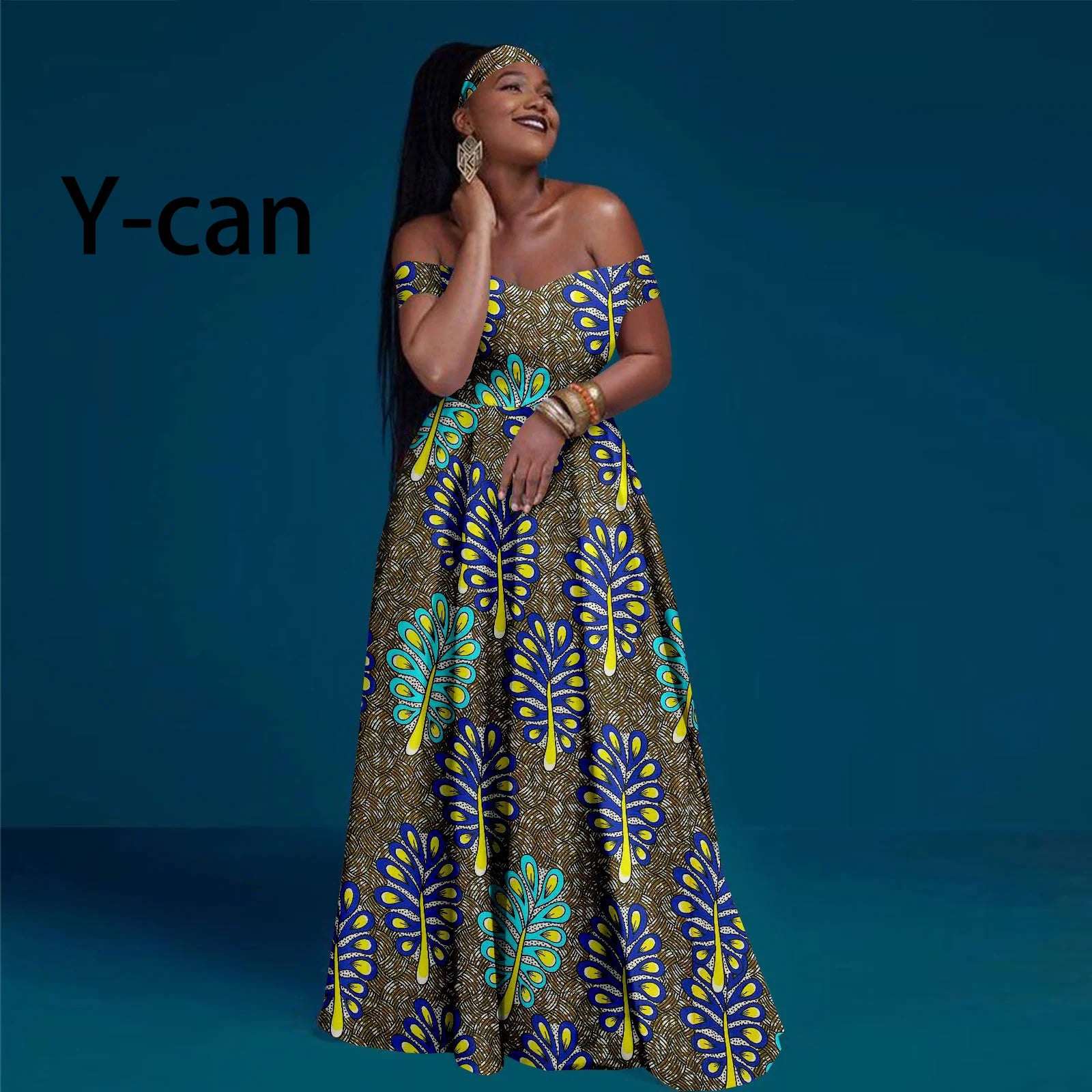 Model wearing an off-the-shoulder maxi dress with a brown, yellow, and blue leaf pattern and a matching headband.