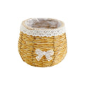 Rustic woven light-brown plant basket featuring a white lace trim, a matching lace bow, and a plastic liner.