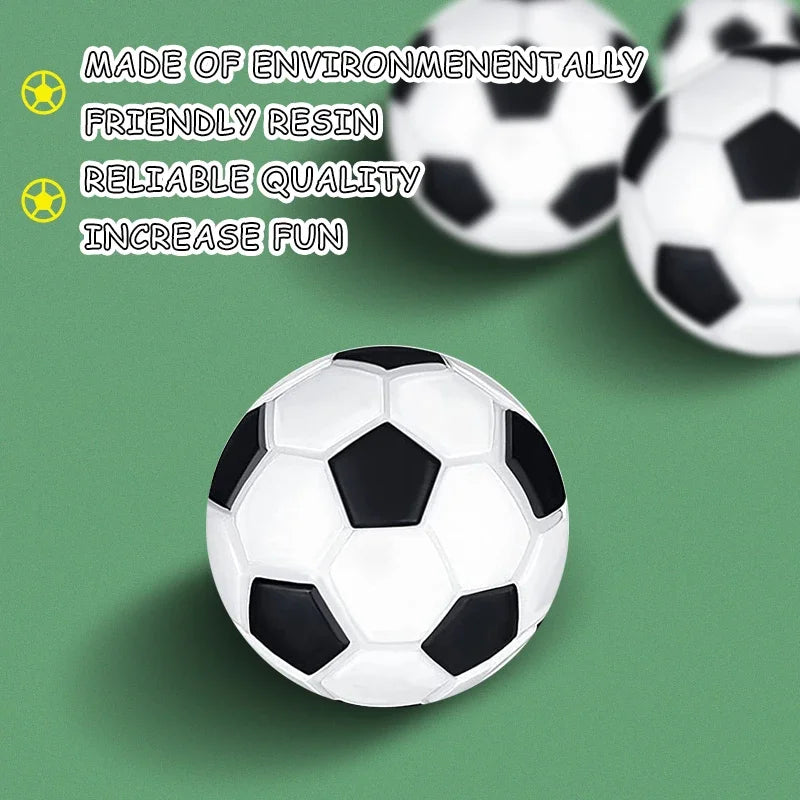 Three classic black and white patterned footballs made of durable resin, set against a green background.