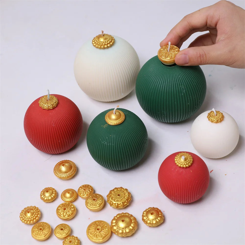 Round ribbed Christmas bauble candles in red, green, and white with decorative gold caps and wicks.