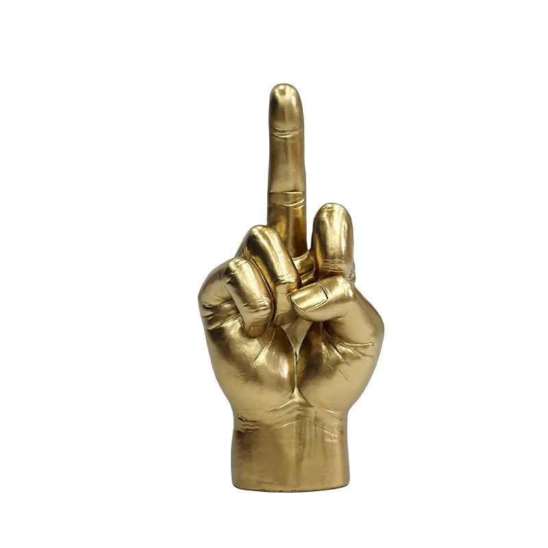 A metallic gold sculpture of a hand making an insulting middle-finger gesture, isolated on a white background.