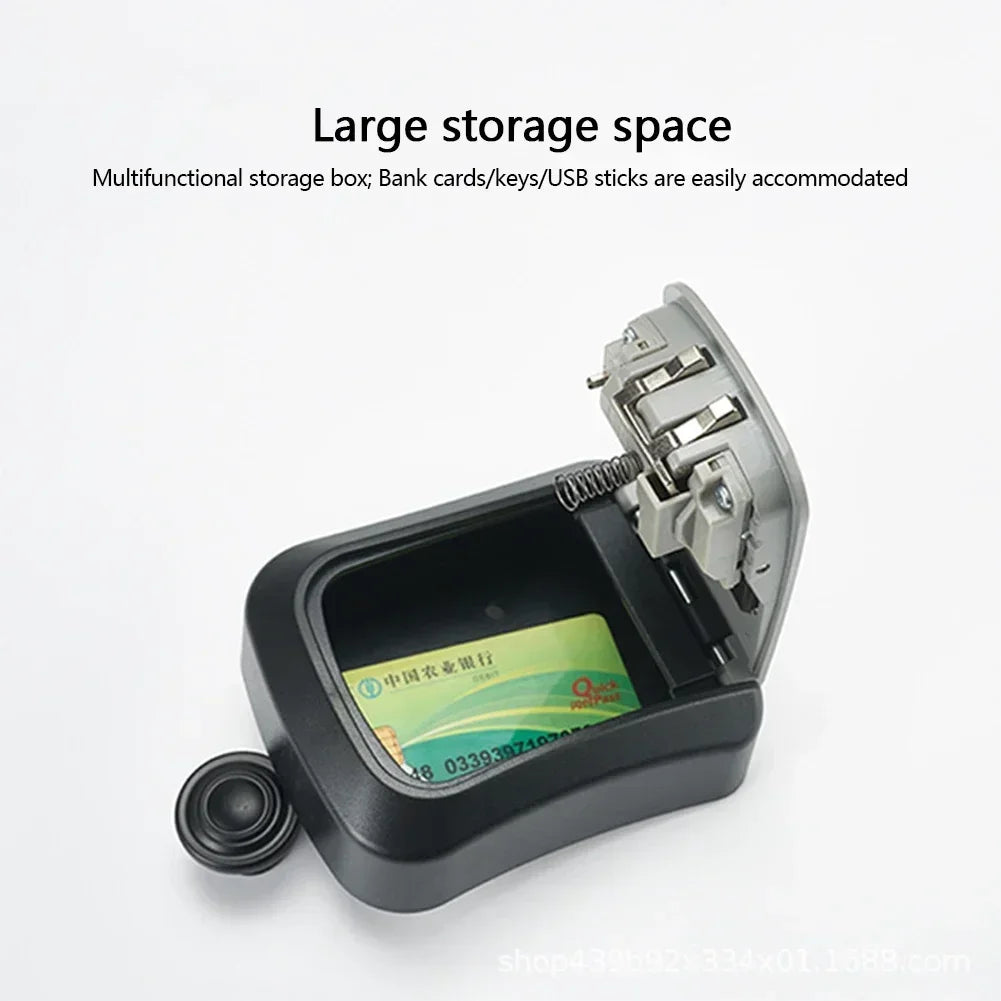 Black plastic wall-mounted key lock box with an open hinged lid showing a bank card stored inside.