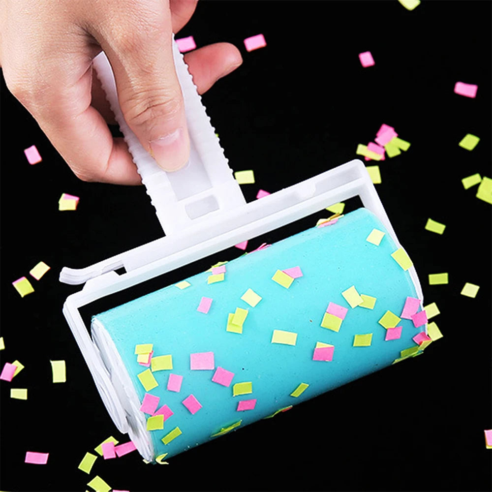 White reusable sticky lint roller covered in small pink and yellow confetti pieces against a black background.