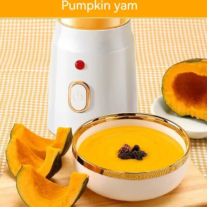 White blender with gold accents, beside a bowl of orange pumpkin soup and fresh pumpkin slices on a checkered mat.