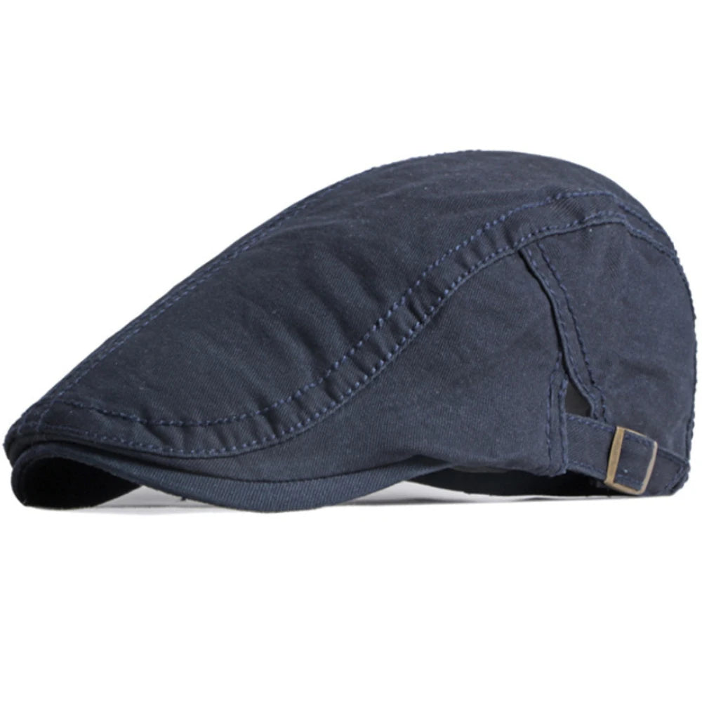 Navy blue cotton flat cap with stitched panel detailing and an adjustable brass-toned side buckle.