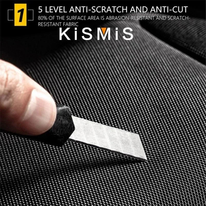 Close-up of a knife blade pressing against the black, cut-resistant fabric of an anti-theft crossbody bag.