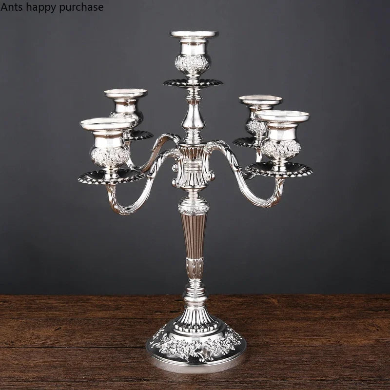 Silver European-style candelabra with five candle holders, ornate curved arms, and floral embossed details.