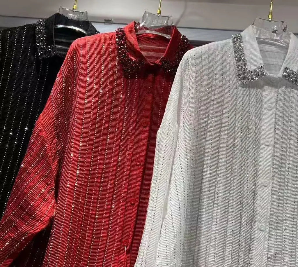 Three button-down shirts in black, red, and white, featuring pleated fabric, vertical glitter stripes, and jewelled collars.