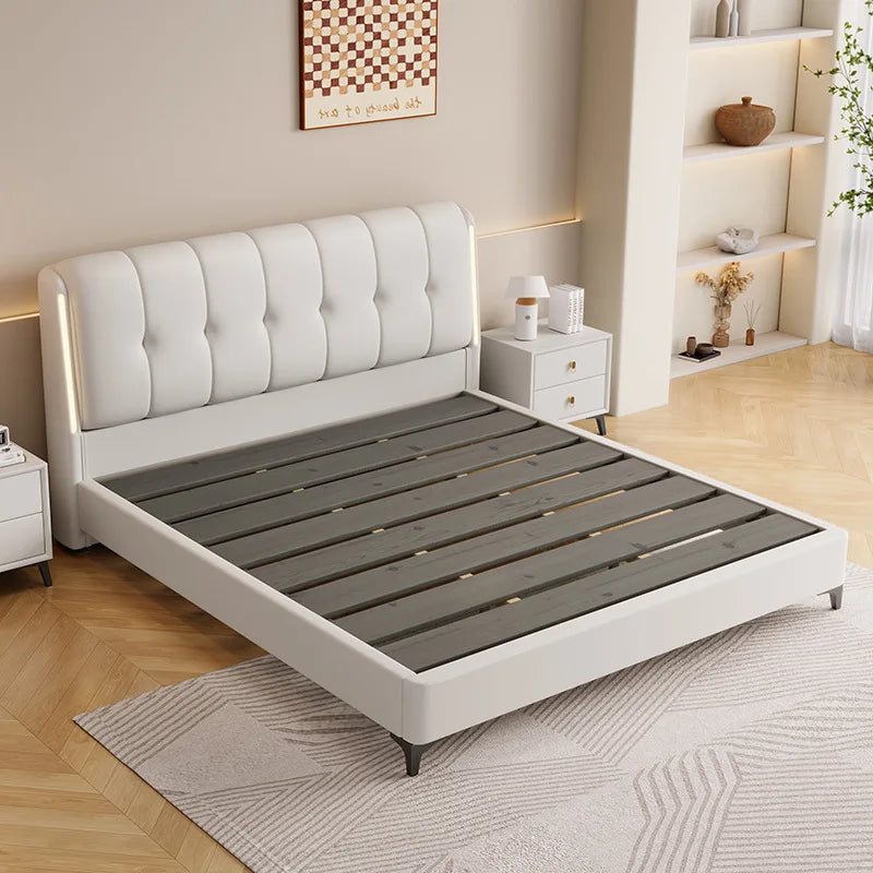 Minimalist cream white storage bed frame with a tufted headboard and dark wooden slatted base.