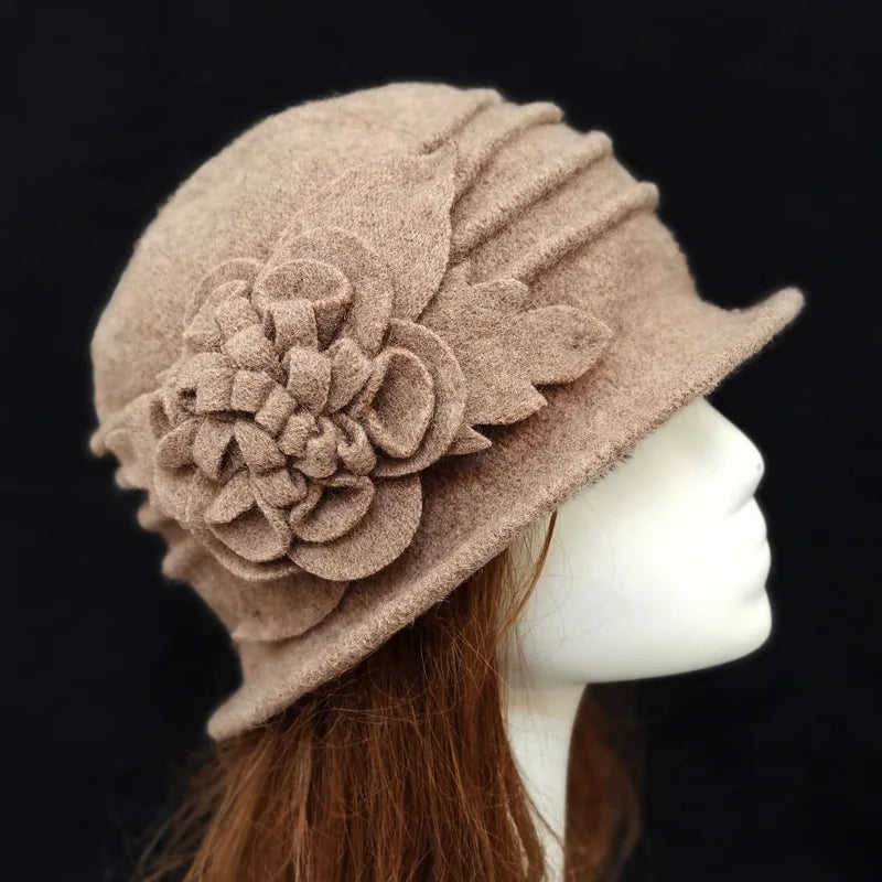 Elegant mocha-brown wool winter hat featuring a pleated crown and a decorative felt flower appliqué on the side.