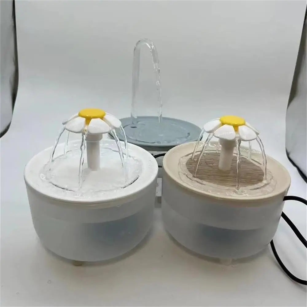 Two round pet water fountains with white, daisy-shaped flower spouts on translucent plastic bases.