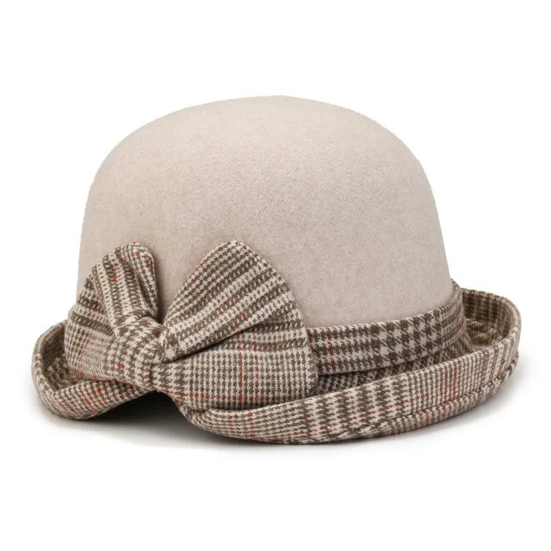 Beige felt winter hat with a rolled brim and a brown and white plaid bow detail.