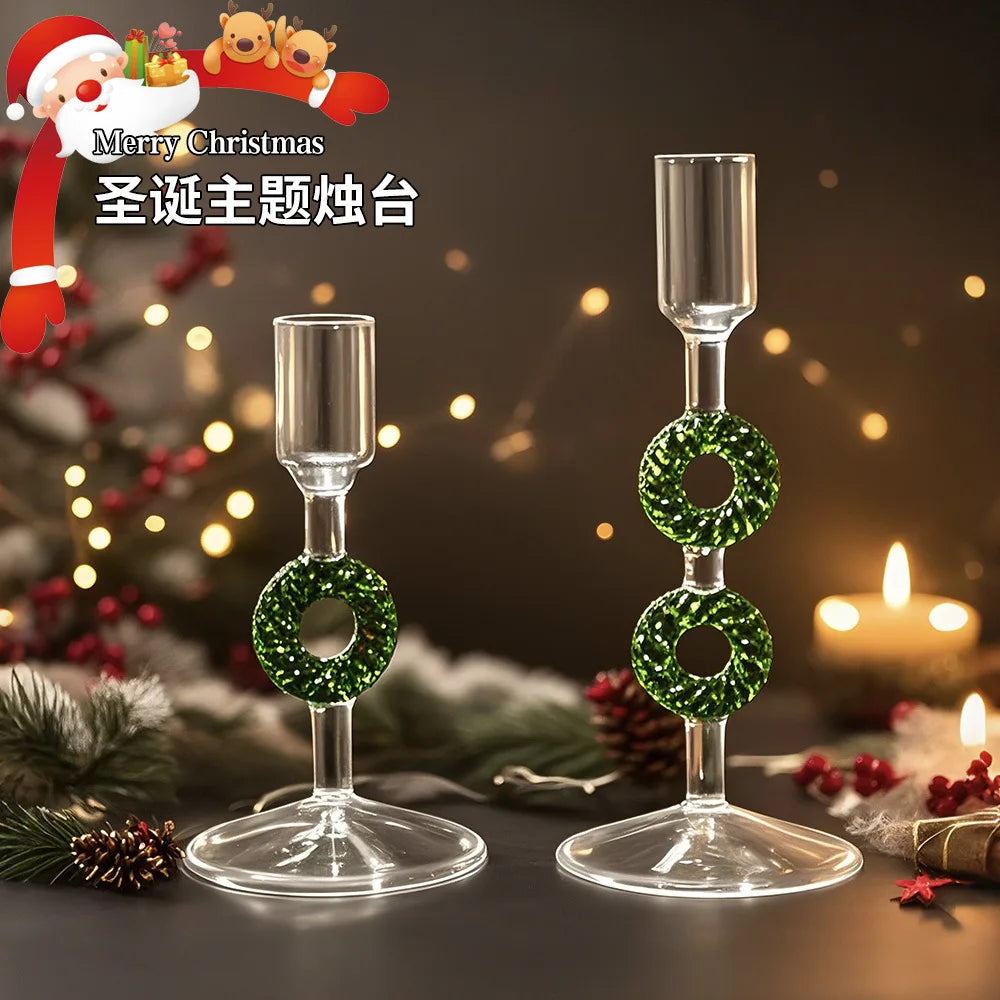 Two clear glass borosilicate candle holders with one and two green glittery wreath accents.