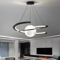 Modern black pendant ceiling light with a glowing moon-like orb and an illuminated orbiting ring design.
