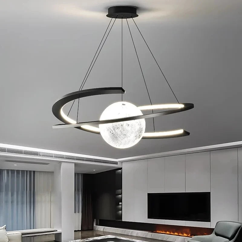 Modern black pendant ceiling light with a glowing moon-like orb and an illuminated orbiting ring design.