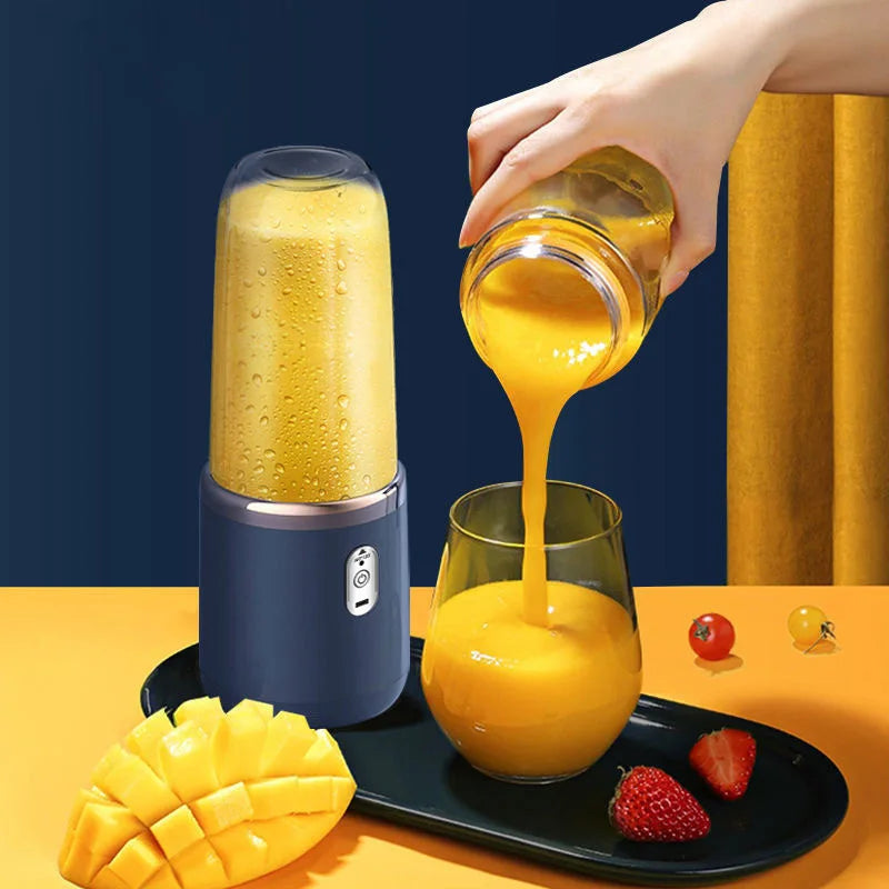 Portable dark blue blender pouring yellow smoothie into a glass on a tray with fresh fruit.