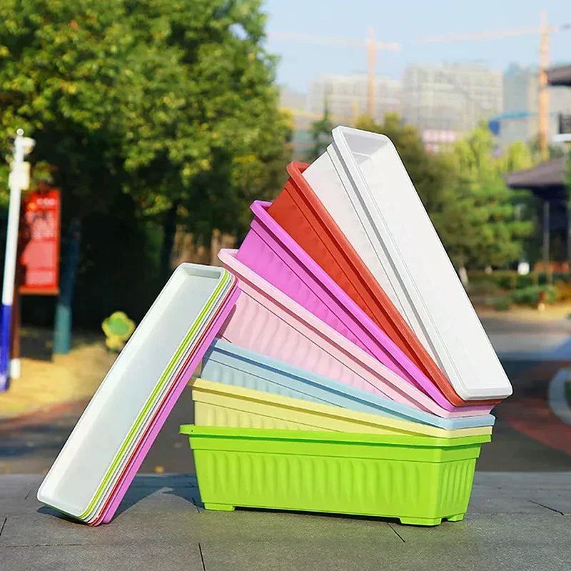 A stack of colorful, rectangular plastic planters in white, red, purple, pink, blue, yellow, and green.