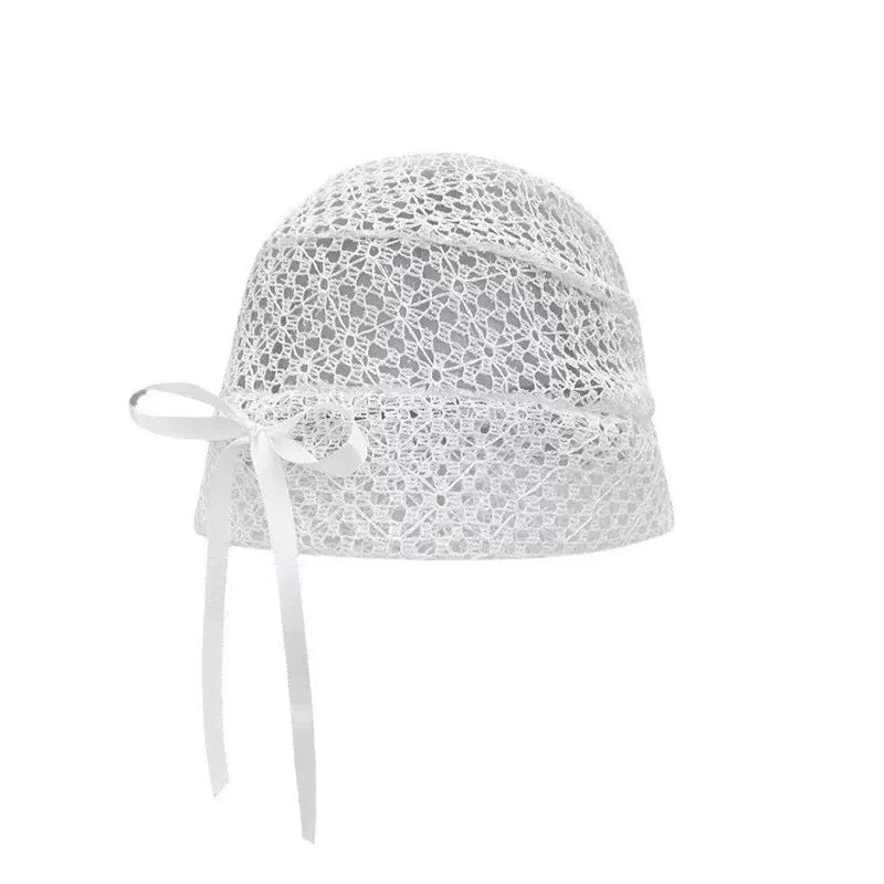 Elegant white cloche hat in delicate floral crochet knit, finished with a decorative side bow and ribbon tie.