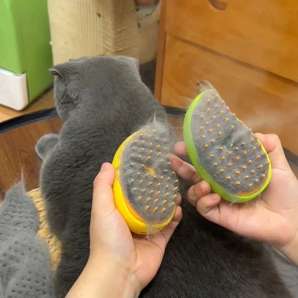 Hands holding two oval yellow and green electric pet grooming brushes, showing gathered grey fur and mist.