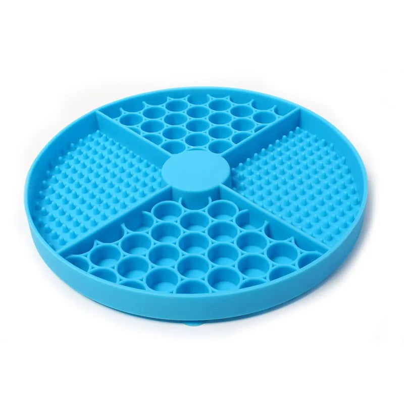 Round bright blue silicone slow-feeder pet mat with a four-section design featuring textured patterns.