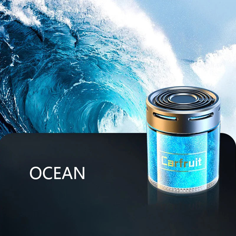 Cylindrical blue ocean-scented car air freshener with a metallic silver top, presented against a wave background.