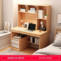 Light wood desk and hutch with integrated shelving, laptop, small lamp, and two lower drawers with white fronts.