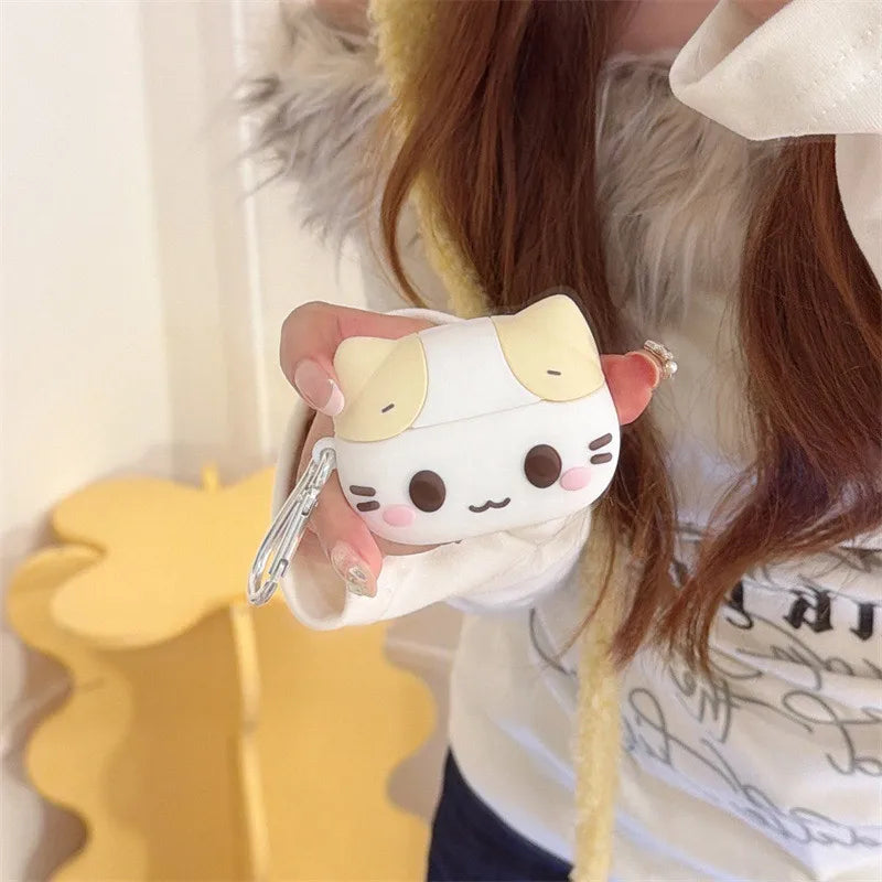 White silicone AirPods case shaped like a cute cat with cream ears, includes a carabiner clip.
