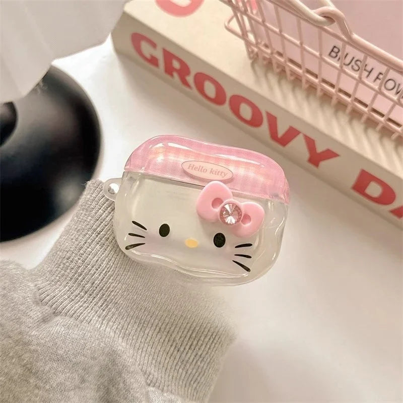 Clear Hello Kitty AirPods case with pink lid, 3D bow, and crystal accent. Durable plastic design.