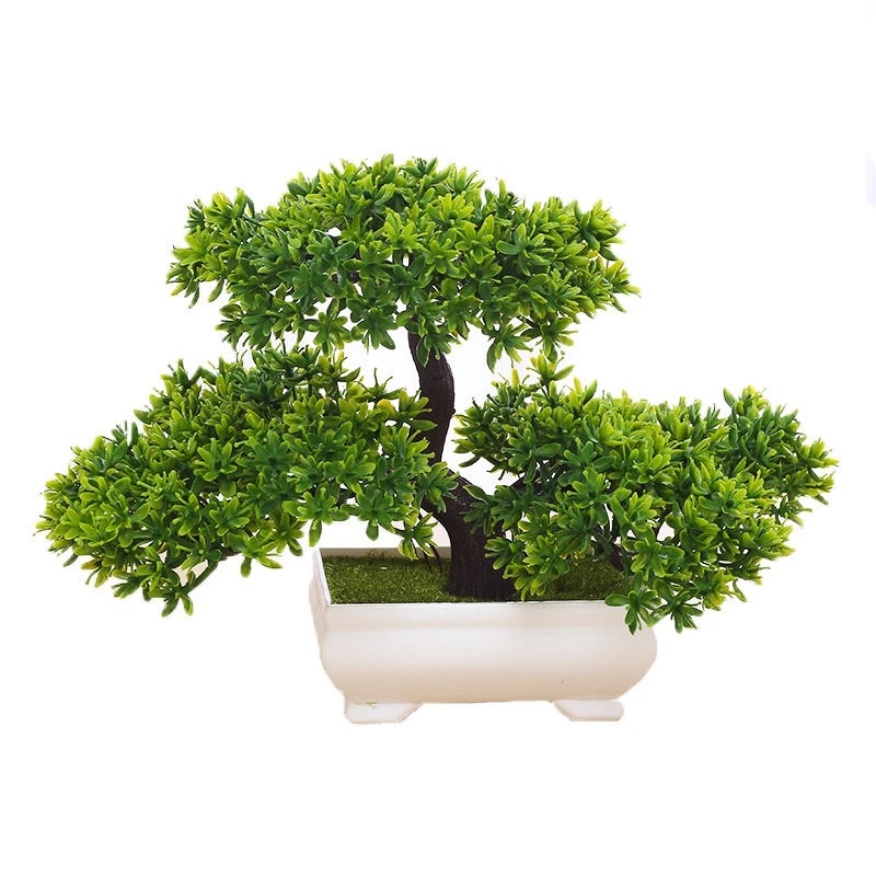 Artificial bonsai tree with vibrant green foliage and a brown trunk, planted in a small rectangular white pot.