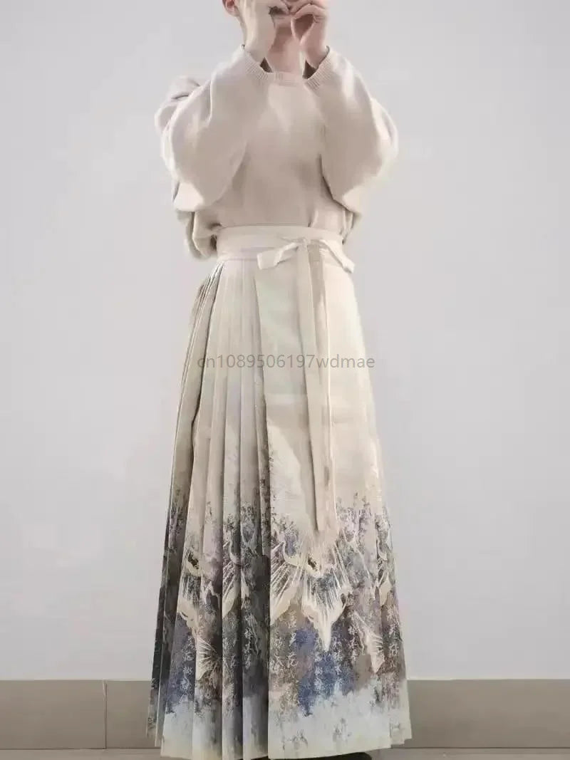 Beige pleated maxi skirt with a tie waist and a decorative nature-inspired print along the hem.