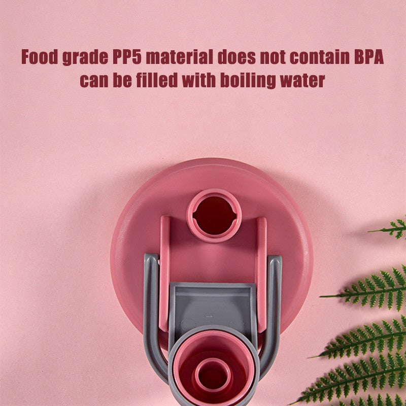 A pink circular bottle lid with a gray flip-top handle and spout, set against a pink background with green foliage.