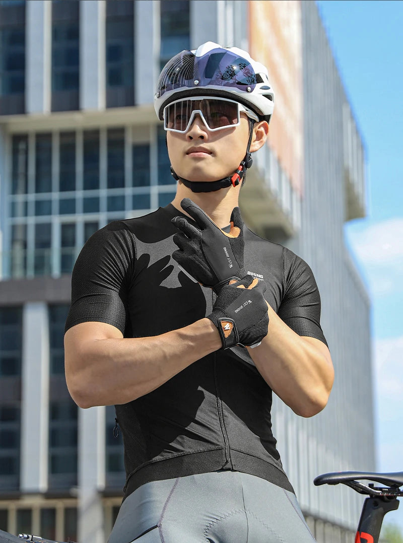 Cyclist wearing a black jersey, white helmet with visor, sports sunglasses, and black fingerless cycling gloves.