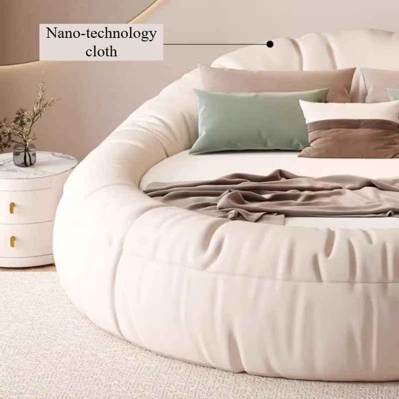 Modern cream-coloured round bed frame with soft, upholstered nano-tech fabric and a minimalist design.