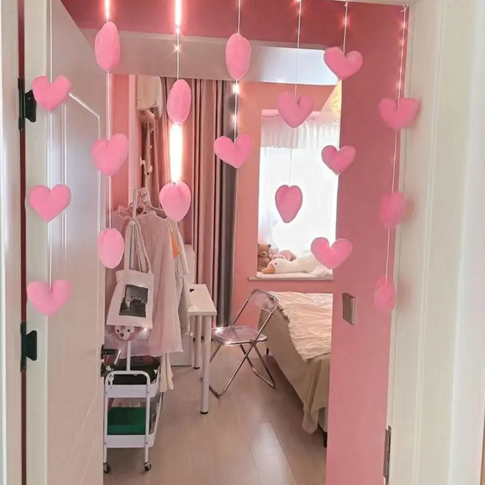 Hanging string of soft pink decorative hearts, displayed in a bedroom doorway as a charming piece of room decor.