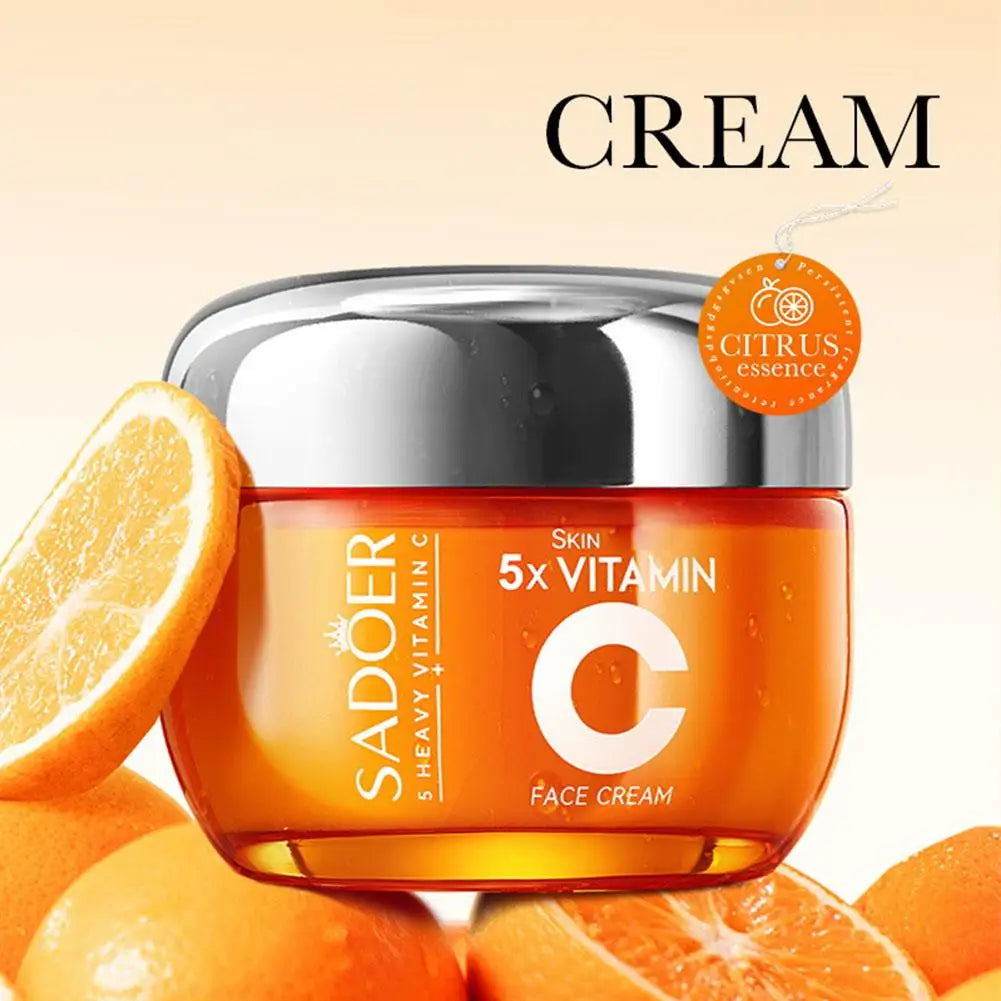 Orange jar of 5x Vitamin C face cream with a silver lid, surrounded by fresh orange slices and citrus essence tag.