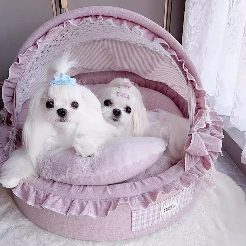 Luxurious pink domed pet bed with ruffled trim and lace lining, holding two white small dogs.