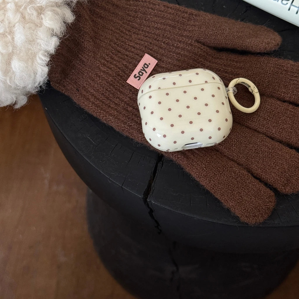 Cream-coloured polka dot silicone case for AirPods, featuring a matching keyring attachment.